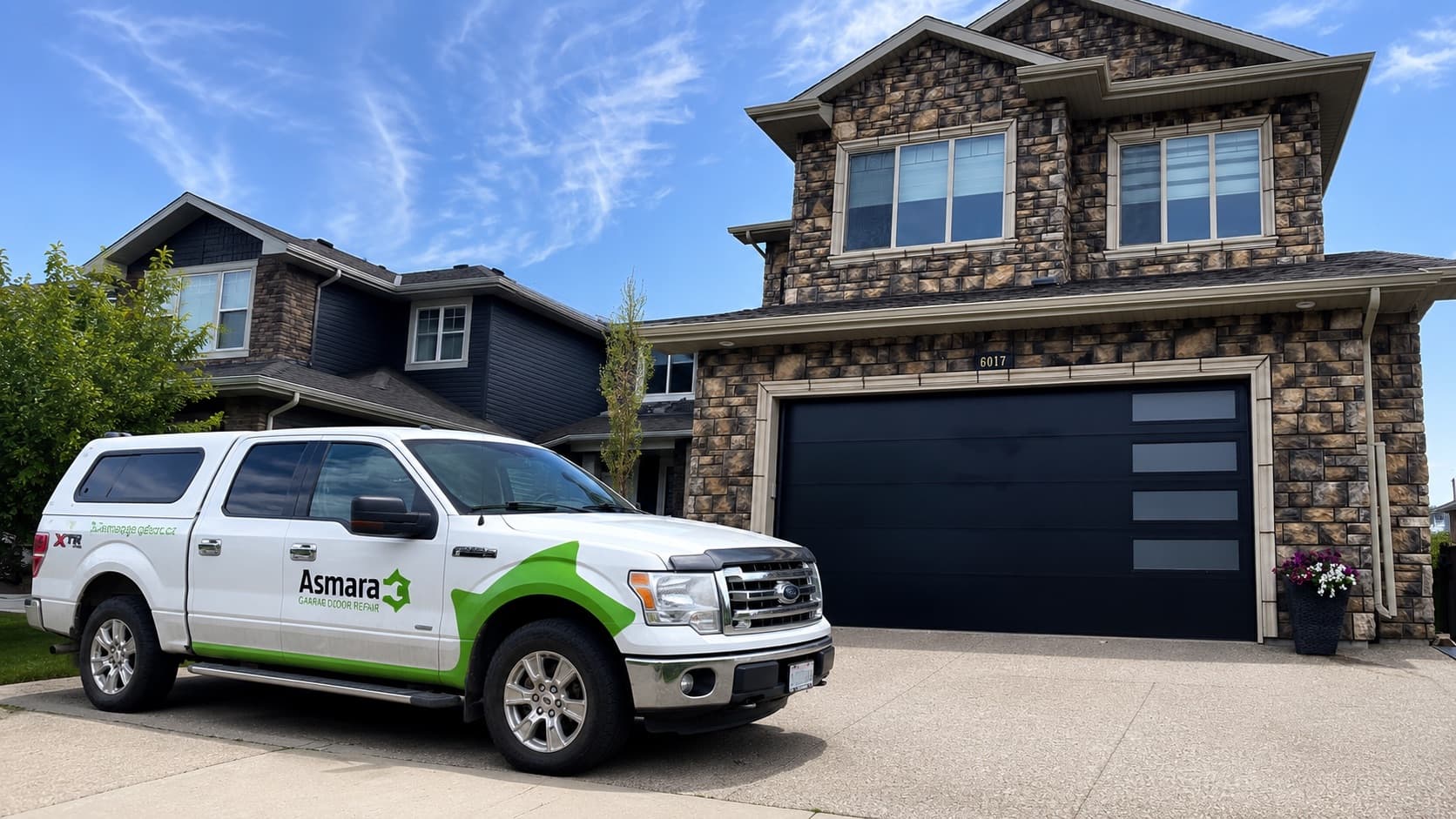 Asmara Garage Doors service truck parked outside an Edmonton home with a new black double garage door